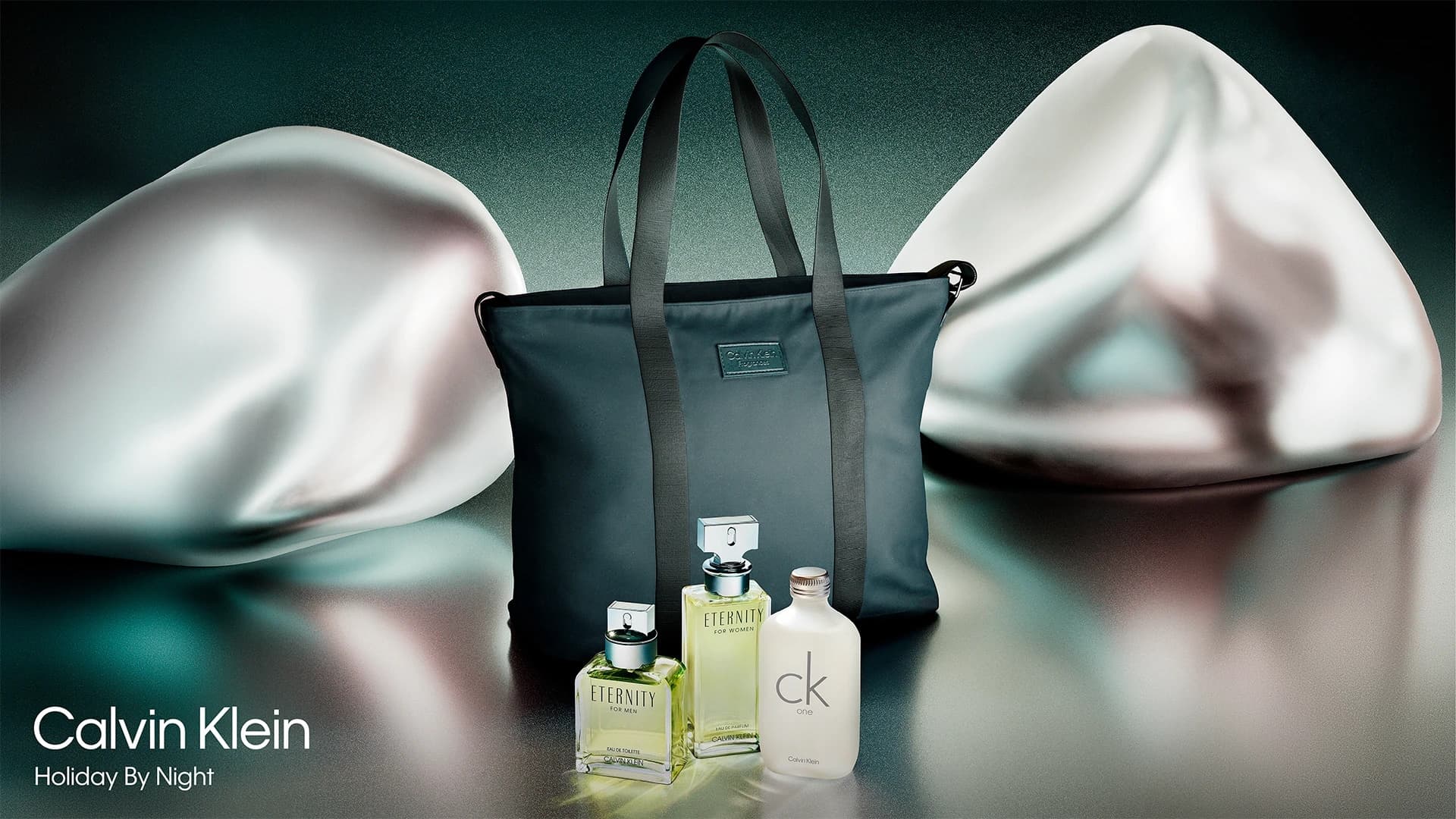 Calvin Klein Holiday by Night still, fragrance gift set with Eternity and CK One around a branded tote.
