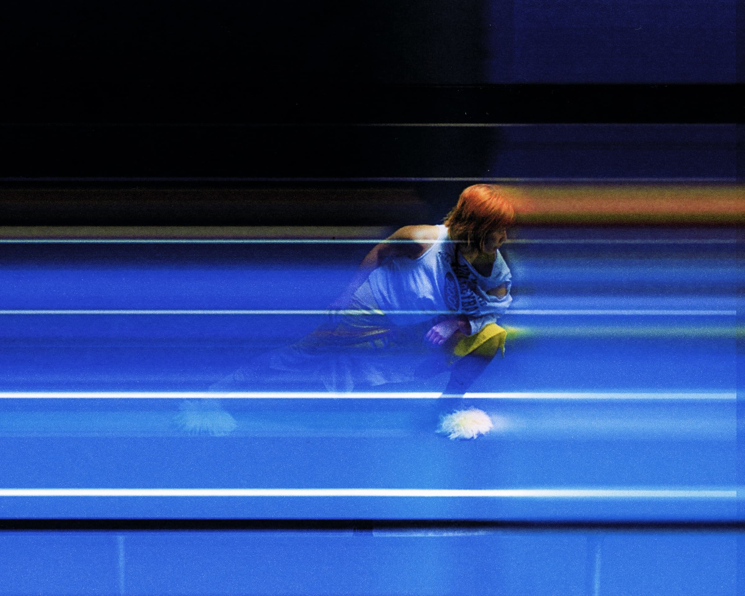 Gina Corrieri SS24 editorial, blue track, motion-blur crouch. Photo by George William Vicary.